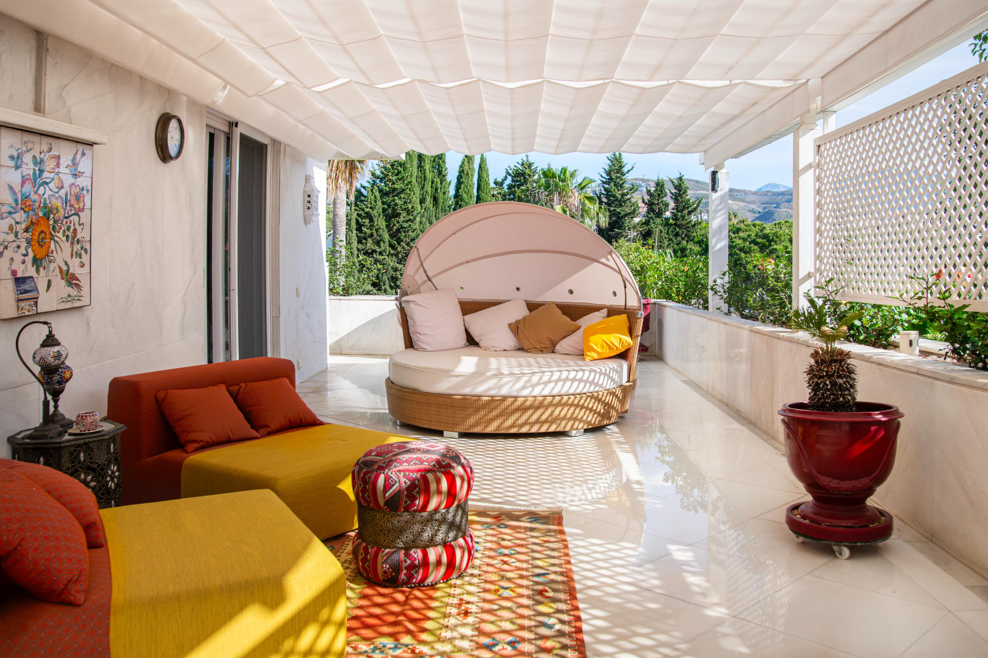 Shaded terrace lounge with circular daybed and Moroccan textiles