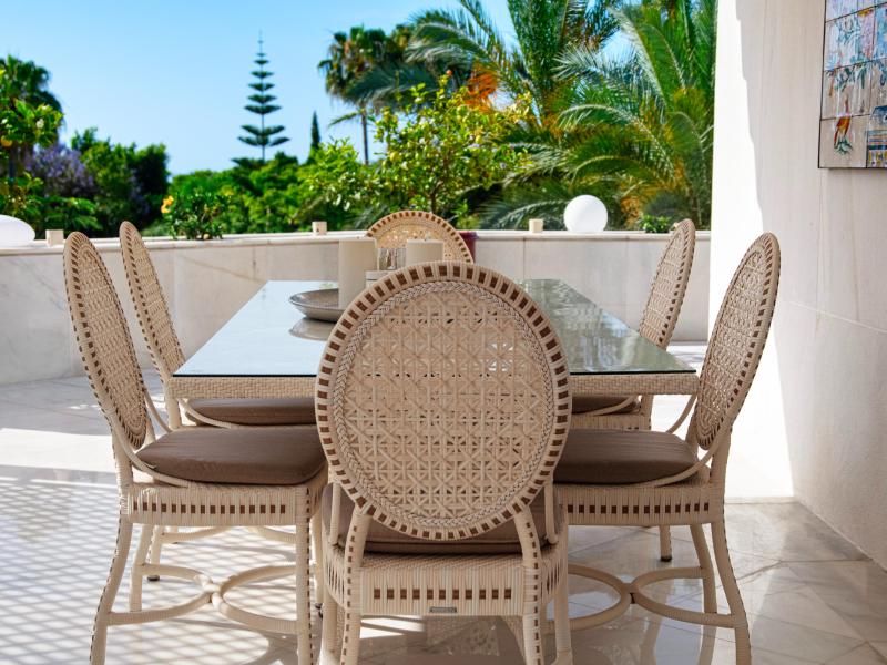 Outdoor dining table with woven chairs on the terrace